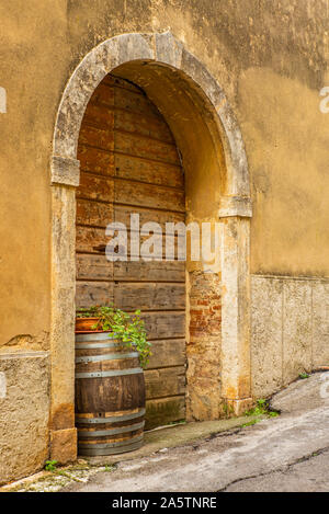 Eine alte Tür und Holzfass in der mittelalterlichen Stadt Massa Marittima in der Toskana Stockfoto