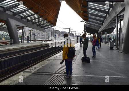 Amsterdam, Holland, August 2019. Im U-Bahnhof Bijlmer Arena, Reisende warten, bis der Zug am Kai. Eine moderne Struktur aus Stahl und Woo Stockfoto