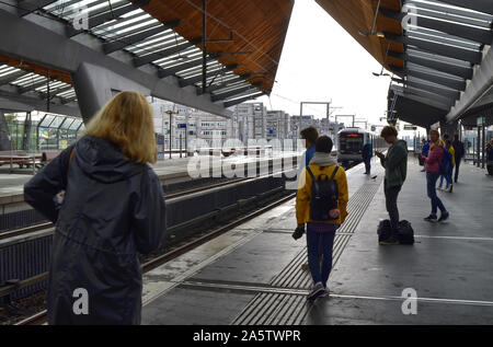 Amsterdam, Holland, August 2019. Im U-Bahnhof Bijlmer Arena, Reisende warten, bis der Zug am Kai. Eine moderne Struktur aus Stahl und Woo Stockfoto