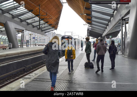 Amsterdam, Holland, August 2019. Im U-Bahnhof Bijlmer Arena, Reisende warten, bis der Zug am Kai. Eine moderne Struktur aus Stahl und Woo Stockfoto