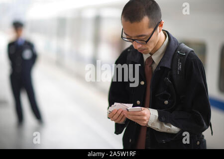 Junge Erwachsene Geschäftsmann Suchen durch Karten auf einem Bahnsteig. Stockfoto