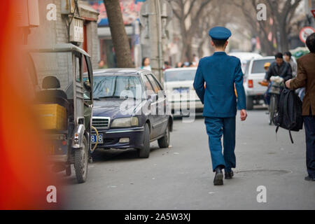 Uniformierte Mann hinunter eine Straße in der Stadt. Stockfoto