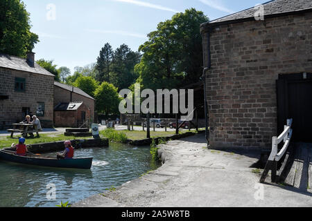 Wharf Buildings am Cromford Canal Terminus in Arkwright's Mill Derbyshire, England Großbritannien Kinder im Kanu Stockfoto