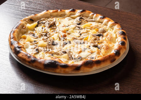 Billige Pizza mit Champignons, Ananas, und Mais. Stockfoto