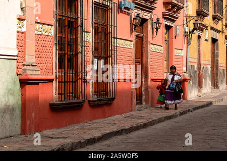 San Miguel de Allende, Guanajuato, Mexiko - Dezember 5, 2004: Frau und Kind in traditioneller Tracht zu Fuß die Straße runter. Stockfoto