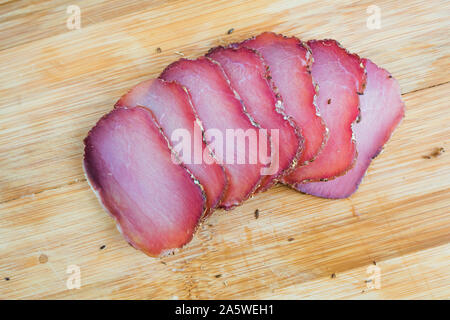 Stücke geschnitten ruckartig auf einer hölzernen Schneidebrett mit Spice Nahaufnahme. Bär Fleisch Snack Stockfoto