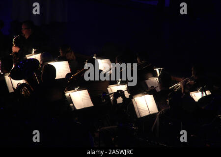 'S Orchestra musikalische Bögen in der Dunkelheit während Konzert gesehen Stockfoto
