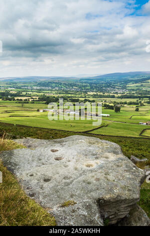 Petroglyphen, oder 'Cup und Ring' Schnitzereien auf 'Pipers Crag Stein'. Ilkley Moor. Yorkshire Stockfoto