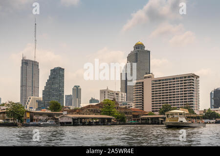 Die Stadt Bangkok, Thailand - 17. März 2019: Chao Phraya Fluss. Wolkenkratzer von Büros und Hotels um der Old Customs House im Quay ruinieren. Iconsam shuttl Stockfoto