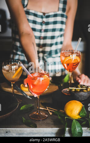 Junge Frau mit Aperol Spritz trinken in Glas in den Händen Stockfoto