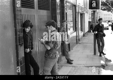 Derry in Nordirland Londonderry. 1979. Soldat der britischen Armee unter Details Katholischer Mann in der Straße. Die Probleme der 1970er Jahre Derry in Nordirland Londonderry GROSSBRITANNIEN HOMER 1979 SYKES Stockfoto