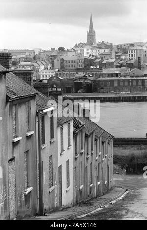 Derry in Nordirland Londonderry. 1979. Die Mühen, die Stadt Derry von der Wasserseite aus, Häuser stiegen die Familien aus der Stadt durch sektiererische Gewalt. Fluss Foyle, St. Eugenes Römisch-katholische Kathedrale 1970 s HOMER SYKES Stockfoto