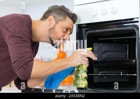 Reifer mann Reinigung Ofen zu Hause Stockfoto