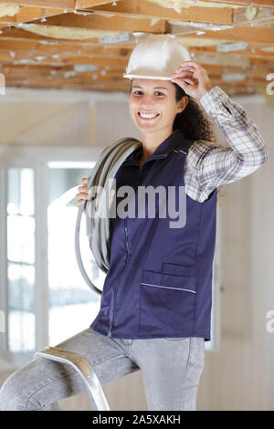 Weibliche builder Kippen ihre hardhat in Entwicklung Eigenschaft Stockfoto