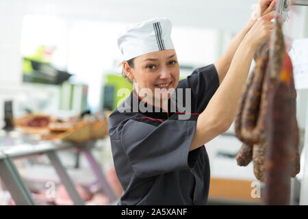 Frau Metzger Verarbeitung Würstchen bei Fleisch Fabrik Stockfoto