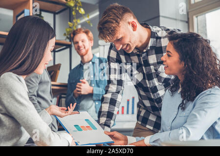 Startupers zusammen arbeiten im Büro Frauen an der Tabelle mit Guy chart fröhliche Sitzung Stockfoto