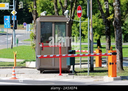 Dunkel Braun metall Sicherheit Stelle mit zwei in der Nähe des TV-CCTV-Überwachungskameras auf die Oberseite mit geschlossenen roten und weißen Barrieren umgeben Stockfoto