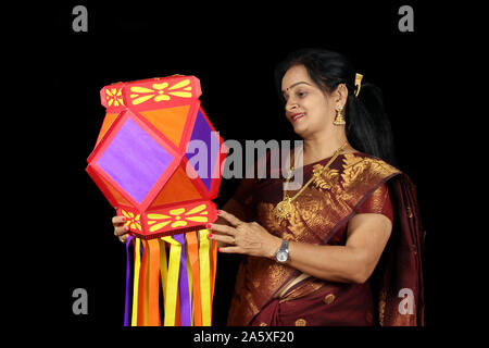 Eine indische Frau glücklich mit ihrer farbenfrohen traditionellen Laterne während Diwali Festival in Indien. Stockfoto