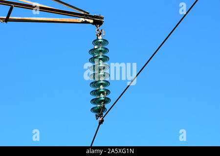 2-in-1 hohe Qualität hohes Glas power line utility Isolatoren holding Einzelne schwarze Kabel auf starke Metall Gebrauchspfosten auf klaren blauen Himmel zurück Stockfoto