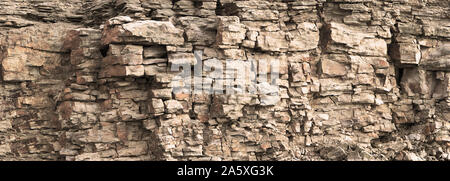 Felsen Felswand Hintergrund. Getönt. Wild abstehenden bröckelnden Geschichteten Blöcke im Steinbruch. Abstrakte Textur für Stein Bergbau. Platz kopieren Stockfoto