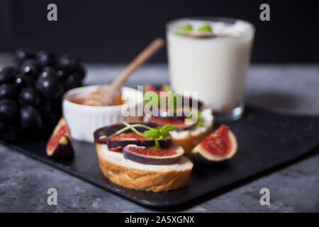 Sandwich mit Frischkäse, Feigen und Honig. Gesunde Ernährung Konzept. Stockfoto