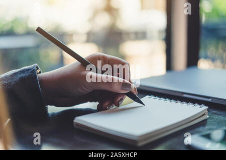 Closeup Bild der Hände einer Frau schreiben auf Notebook auf dem Tisch Stockfoto