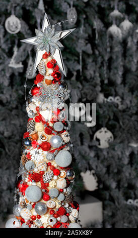 Ein großer Stern an der Spitze und Weihnachten Spielzeug, Kegel und Kugeln hängen auf einer imaginären Weihnachtsbaum. Stockfoto