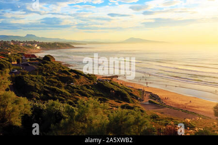 Der Strand und die Wellen des Ozeans an der baskischen Küste bei Sonnenuntergang. Stockfoto