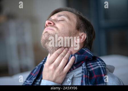 Man Gefühl krank und müde, während Angina in Stockfoto