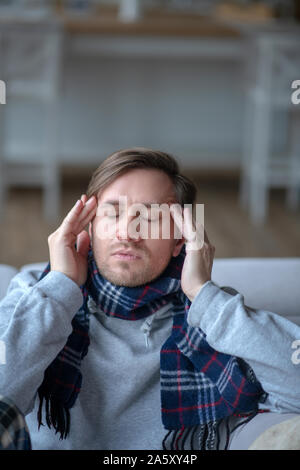 Dunkelhaarige Mann seinen Kopf zu berühren, während mit Kopfschmerzen. Stockfoto