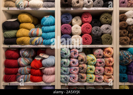Anzeige von bunten Bällen aus Wolle in den Regalen der steppke Upp' Nähen und Stricken Kurzwaren shop, Uppingham, Rutland, England, UK gestapelt Stockfoto