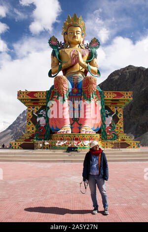 Reisende thaifrau Reisen besuchen Sie stand für ein Foto mit Maitreya Buddha Statue in der Nähe Diskit Kloster in Nubra Valley Village in Leh, Ladakh wh Stockfoto