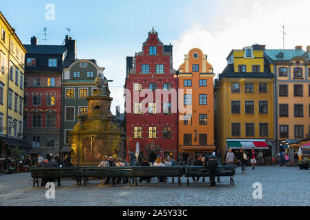 Gamla Stan Stockholm, Rückansicht bei Dämmerung von Menschen, die auf Bänken auf dem Marktplatz (Stortorget) der Stockholmer Altstadt (Gamla Stan), Schweden, sitzen Stockfoto