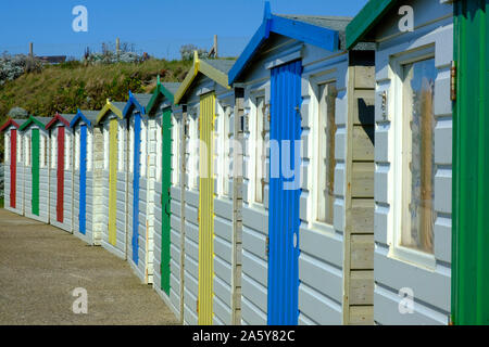 Mehrfarbige Umkleidekabinen am Strand mit Promenade mit Blick auf den Strand an der Bude Cornwall England Stockfoto