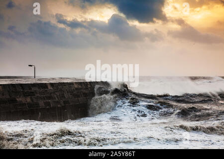 Wellen, die über dem Cobb in Lyme Regis in Dorset. Stockfoto