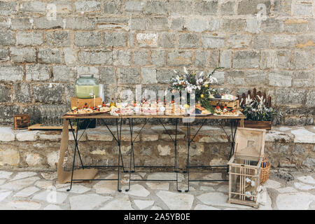 Catering oder Food Service außerhalb des Hauses. Tische mit Essen im rustikalen Stil dekoriert. Die Vorbereitung für die Feier. Stockfoto