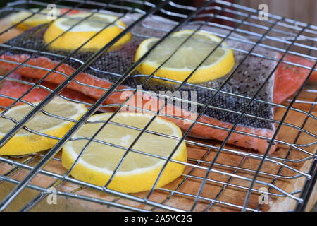 Lachsfilets mit Zitronenscheiben in Bratrost. Bereit für Grill. Stockfoto