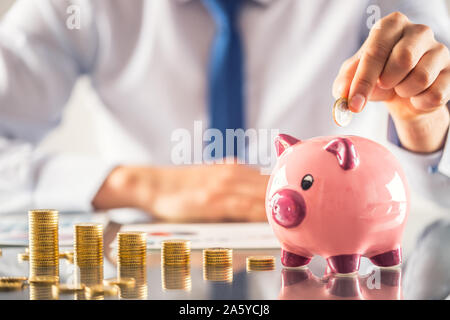 Banker Buchhalter oder Versicherer Geld in ein Sparschwein. Finanzielle chart von Münzen Business Konzept Stockfoto