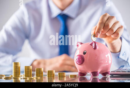 Banker Buchhalter oder Versicherer Geld in ein Sparschwein. Finanzielle chart von Münzen Business Konzept Stockfoto