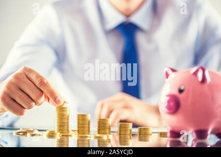 Banker Buchhalter oder Versicherer baut finanzielle Chart aus Gold Münzen Stockfoto