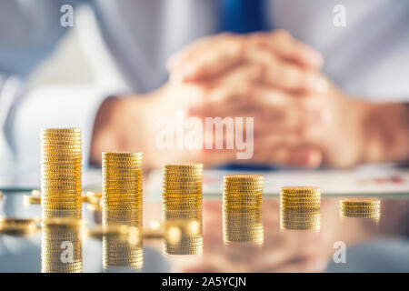 Banker Buchhalter oder Versicherer baut finanzielle Chart aus Gold Münzen Stockfoto