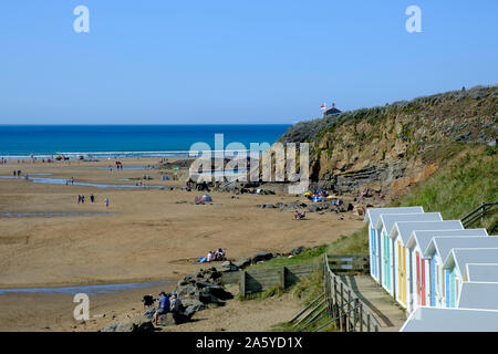 Mehrfarbige Umkleidekabinen am Strand mit Promenade mit Blick auf den Strand an der Bude Cornwall England Stockfoto