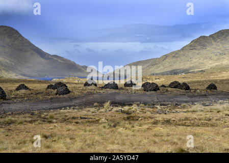 Irland Galway, 2018 - Bogland in Irland, mit Stapeln von Rasen trocknen unter der Sonne und im Winter Füle. Stockfoto