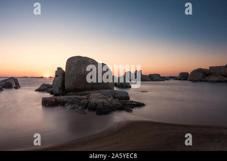 Lange Belichtung Bild der Sonnenaufgang über dem Mittelmeer und große Granitblöcke, die an der Küste von Cavallo Insel n die Lagoon Archipel von Corsi Stockfoto