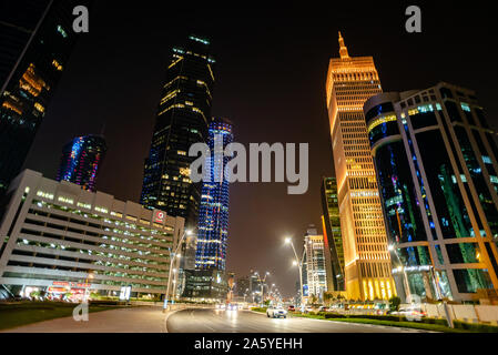 Eine ruhige Urban Street im Finanzdistrikt von Doha in der Nacht. Die Al Asmakh Turm ist in gelbes Licht beleuchteten Stockfoto