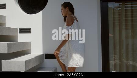 Junge Frau in Kleid Treppensteigen Stockfoto