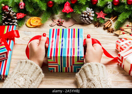 Blick von oben auf die weiblichen Strebe bis ins neue Jahr auf festliche Holz- Hintergrund. Tannenbaum und Urlaub Dekorationen. Weihnachten Konzept. Stockfoto