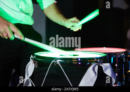 Nahaufnahme der Hand einer drummer drums spielen Licht im Dunkeln. geringe Tiefenschärfe. Stockfoto