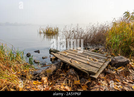 Ein Ponton aus Holz über große Steine in der Nähe der blauen Fluss Dnepr wartet für die Fischer. Stockfoto
