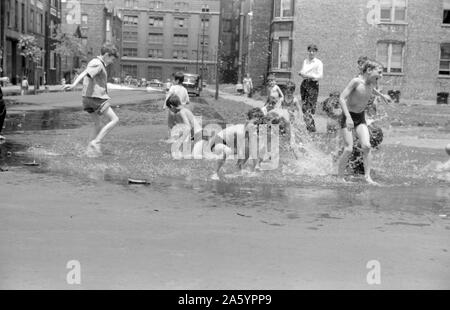 Kinder in einer Straße sind Abkühlung im Wasser vom Hydranten, Chicago, Illinois. 1941. Stockfoto